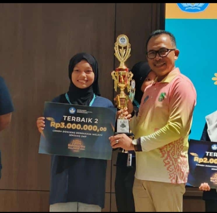 E. Aura Naqiyya Qalesya saat menerima penghargaan atas prestasi yang diperolehnya. F. Redaksi