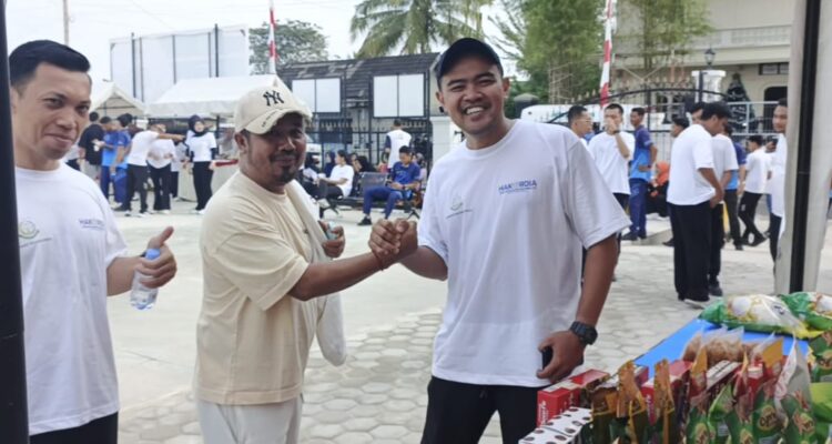 Safarudin (Tengah) Kepala Bapenda Lingga saat memborong beras di stand Koperasi Merah Putih Desa Batu Kacang untuk dibagikan kepada masyarakat. F. Redaksi