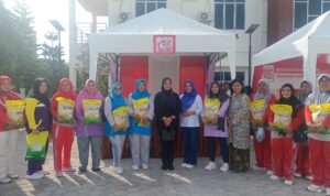 Maya Sari, Ketua DPRD Kabupaten Lingga foto bersama dengan masyarakat yang mendapatkan beras. F. Redaksi