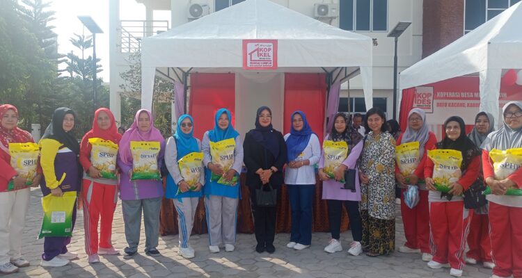 Maya Sari, Ketua DPRD Kabupaten Lingga foto bersama dengan masyarakat yang mendapatkan beras. F. Redaksi