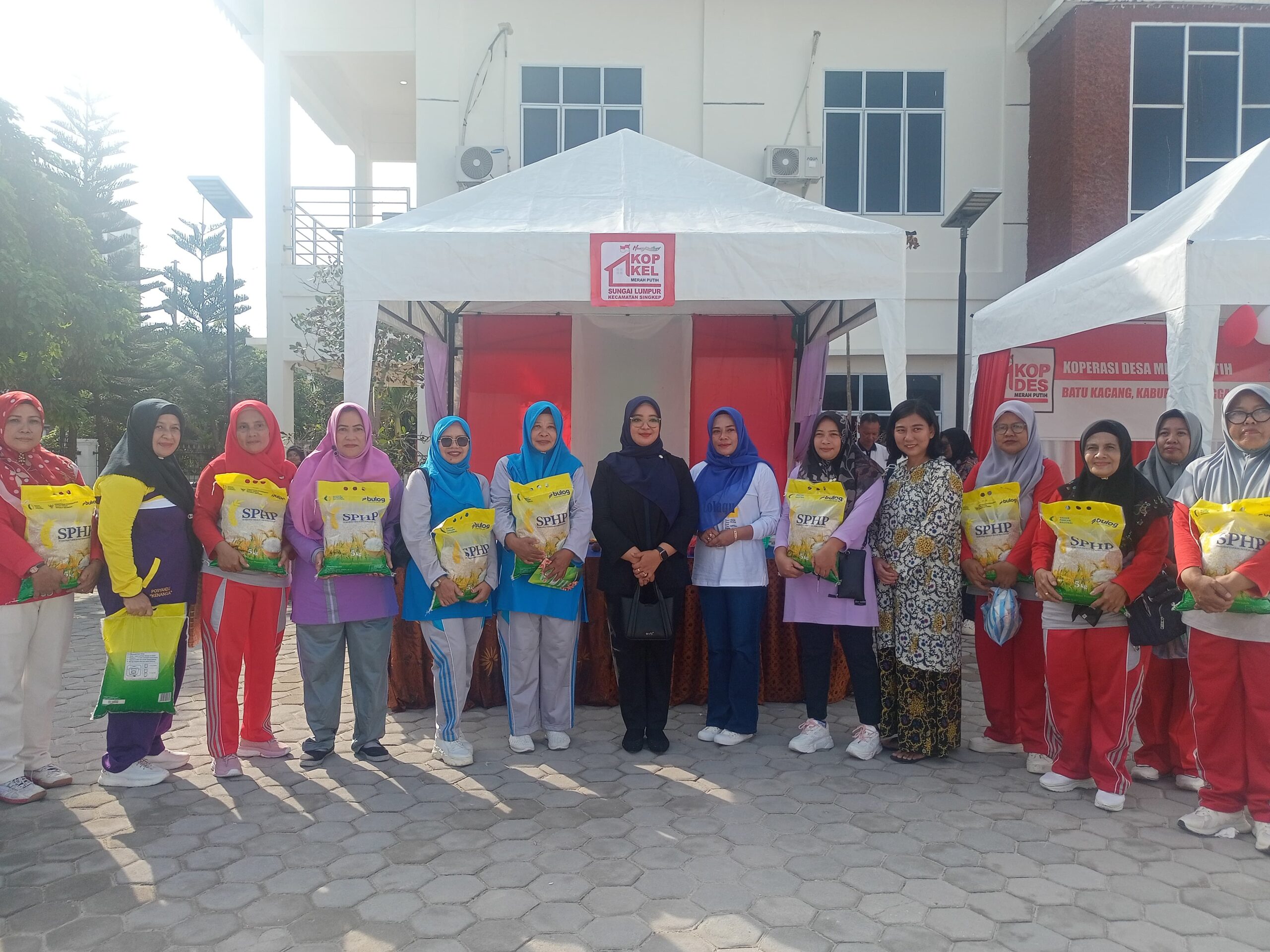 Maya Sari, Ketua DPRD Kabupaten Lingga foto bersama dengan masyarakat yang mendapatkan beras. F. Redaksi